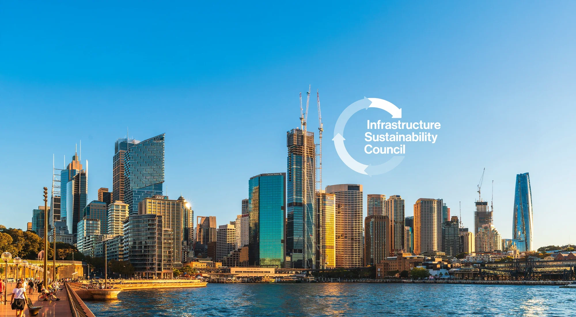 Infrastructure Sustainability Council case study header featuring Sydney harbour waterfront skyline with modern skyscrapers and construction cranes at golden hour, overlaid with ISC circular arrow logo in white