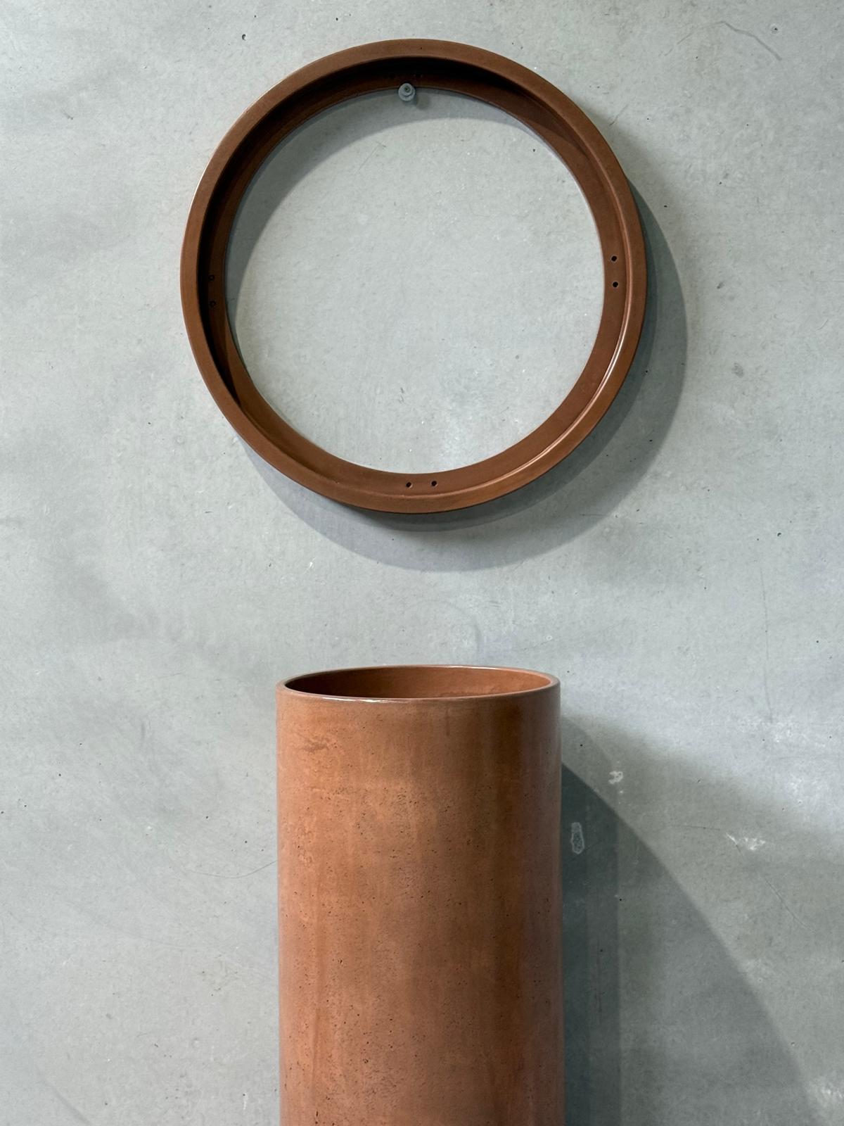 Tallow Made handcrafted concrete homewares featuring a timber framed circular mirror and cylindrical vessel photographed on raw concrete surface
